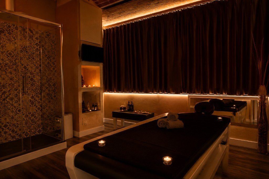 Sala privada de masajes Dharma Barcelona con camilla, ducha e iluminación cálida